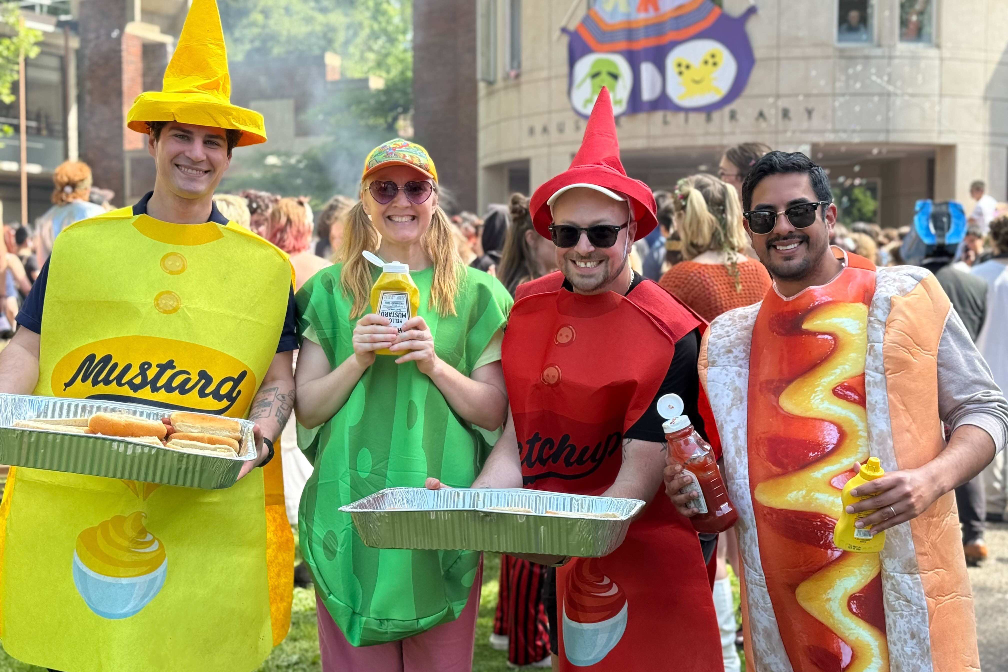 Alumni and Staff dressed as hot dog condiments at thesis burning