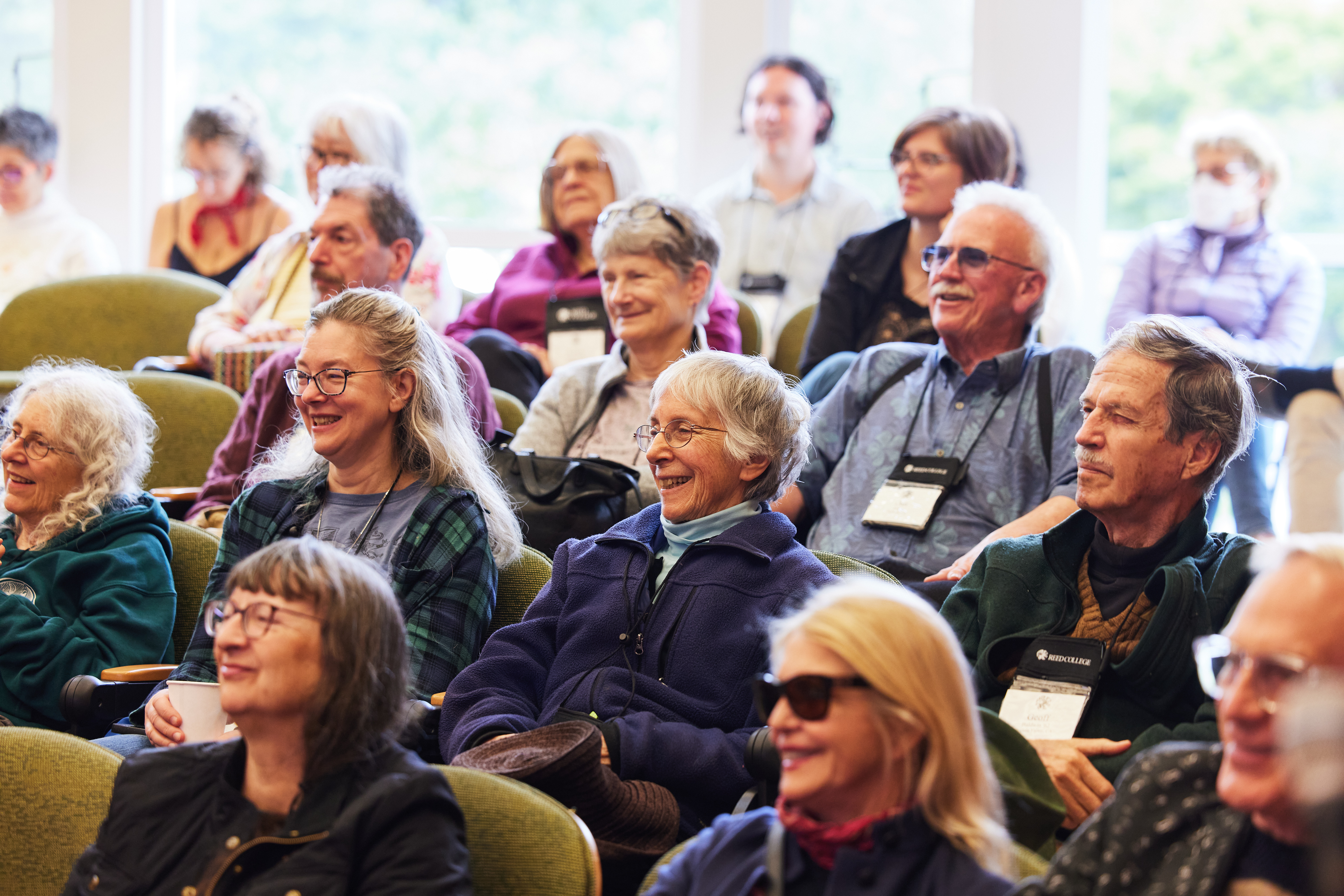 People sitting in auditorium, laughing. 